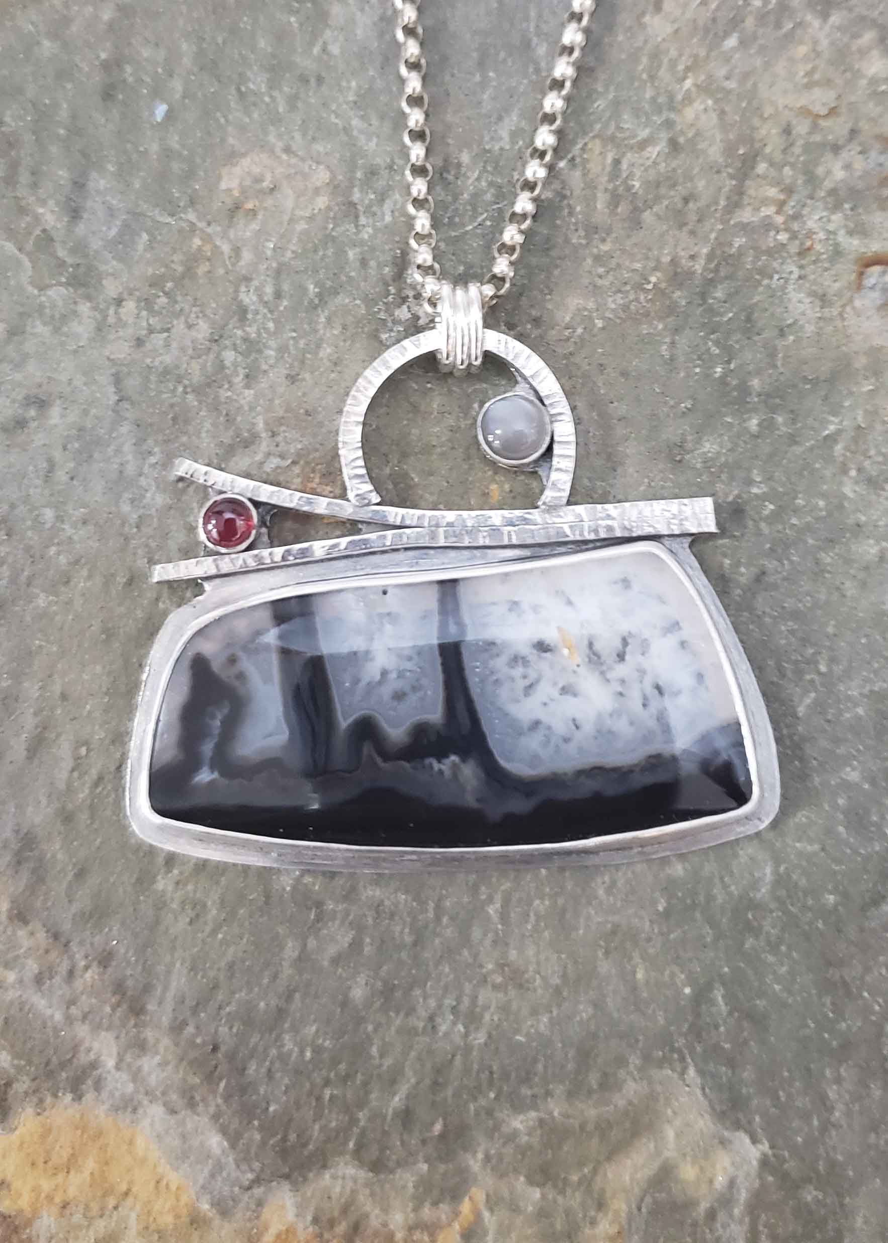 Black and white with a splash of read in this silver pendant by Dona Miller.