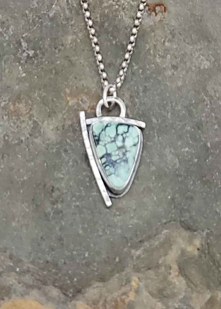 Tide Pool - turquoise and black New Lander in a silver pendant.
