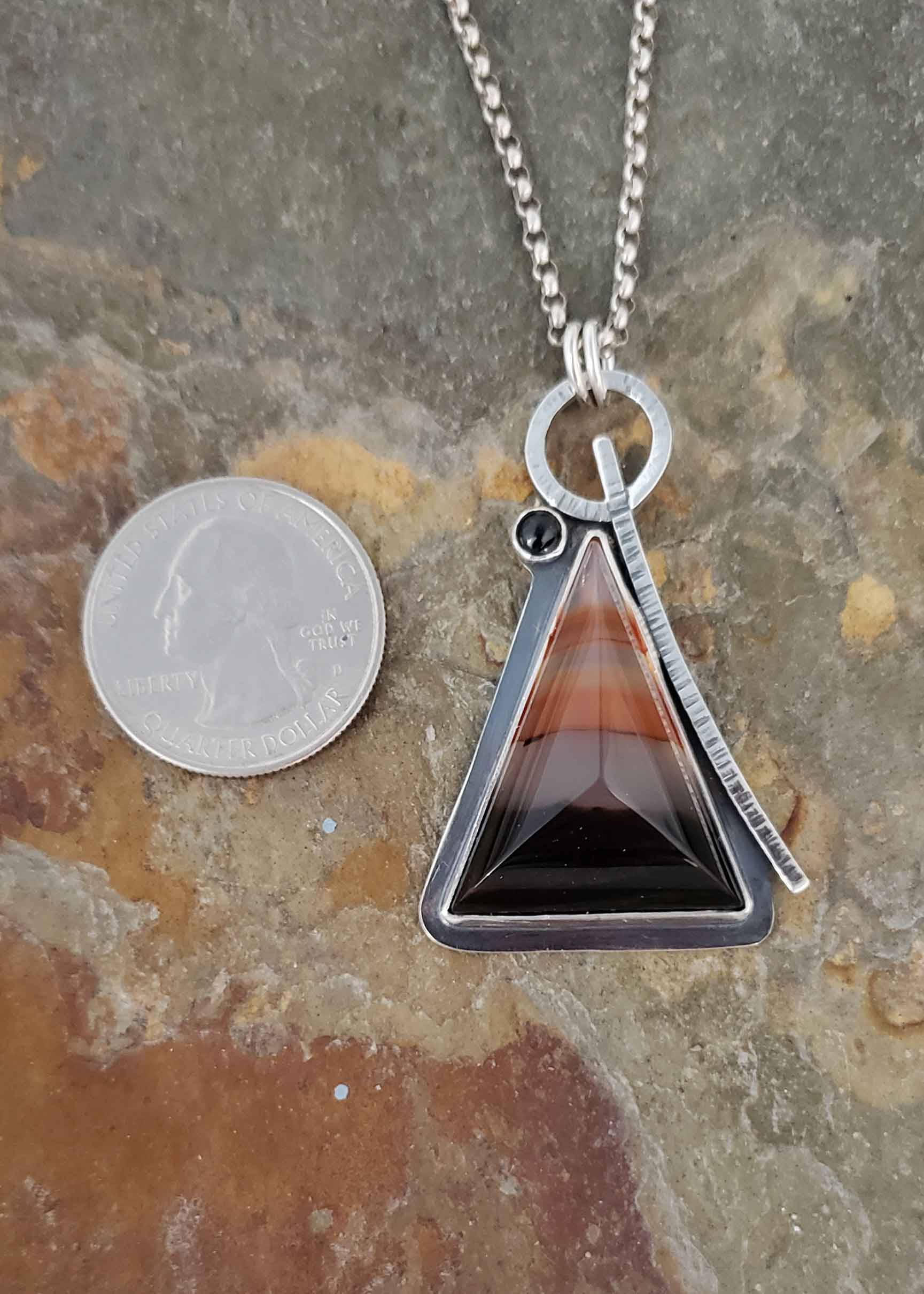 Pyramid strength in this ornage and black pendant.