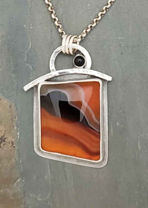 Warm tangerine oranges and black pendant in Bumblebee Chalcedony and Black Spinel.