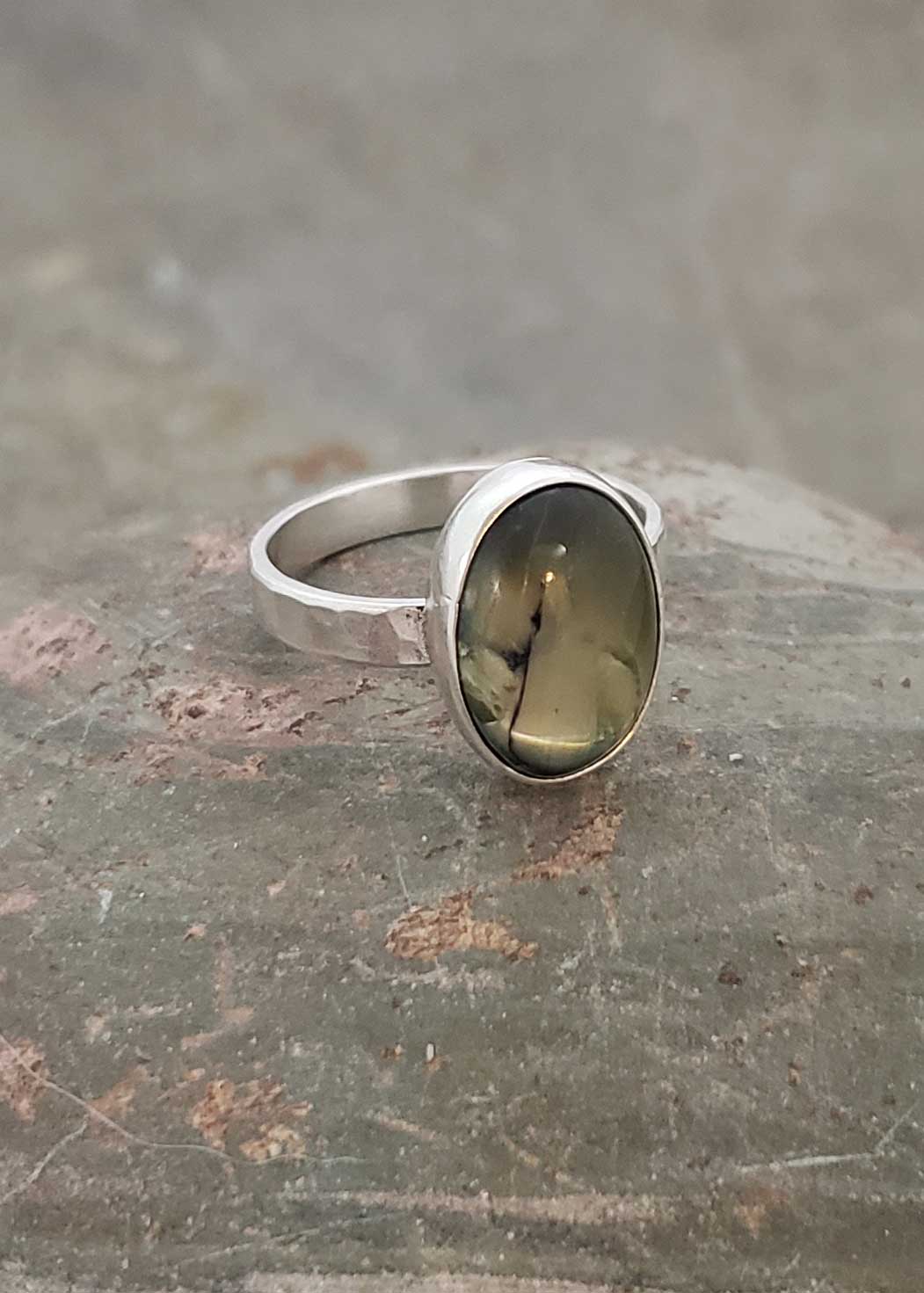 glow of olive green is captured in this silver ring, by Dona Miller