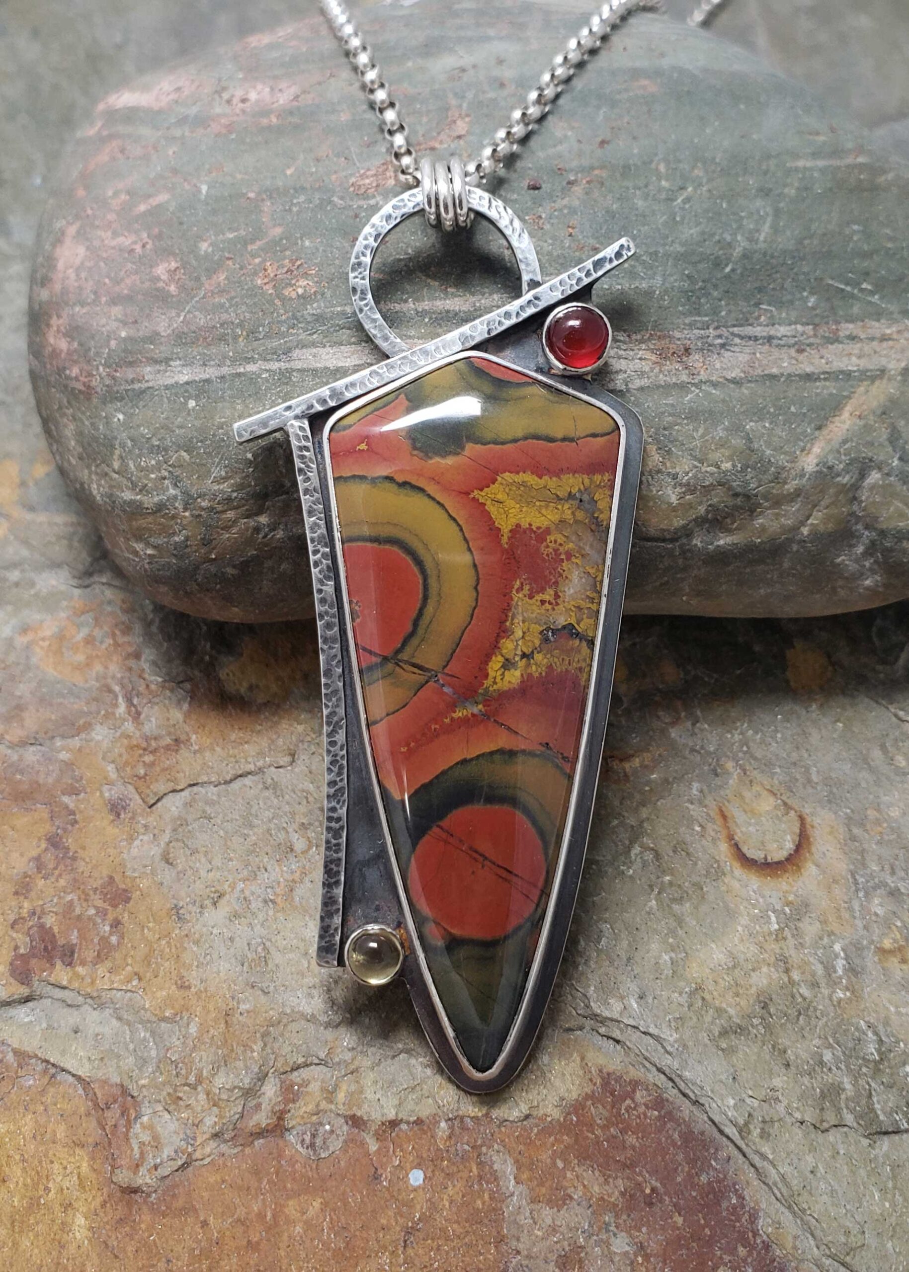 reds, golds and greens make a bold abstract statement in this silver pendant, by Dona Miller 