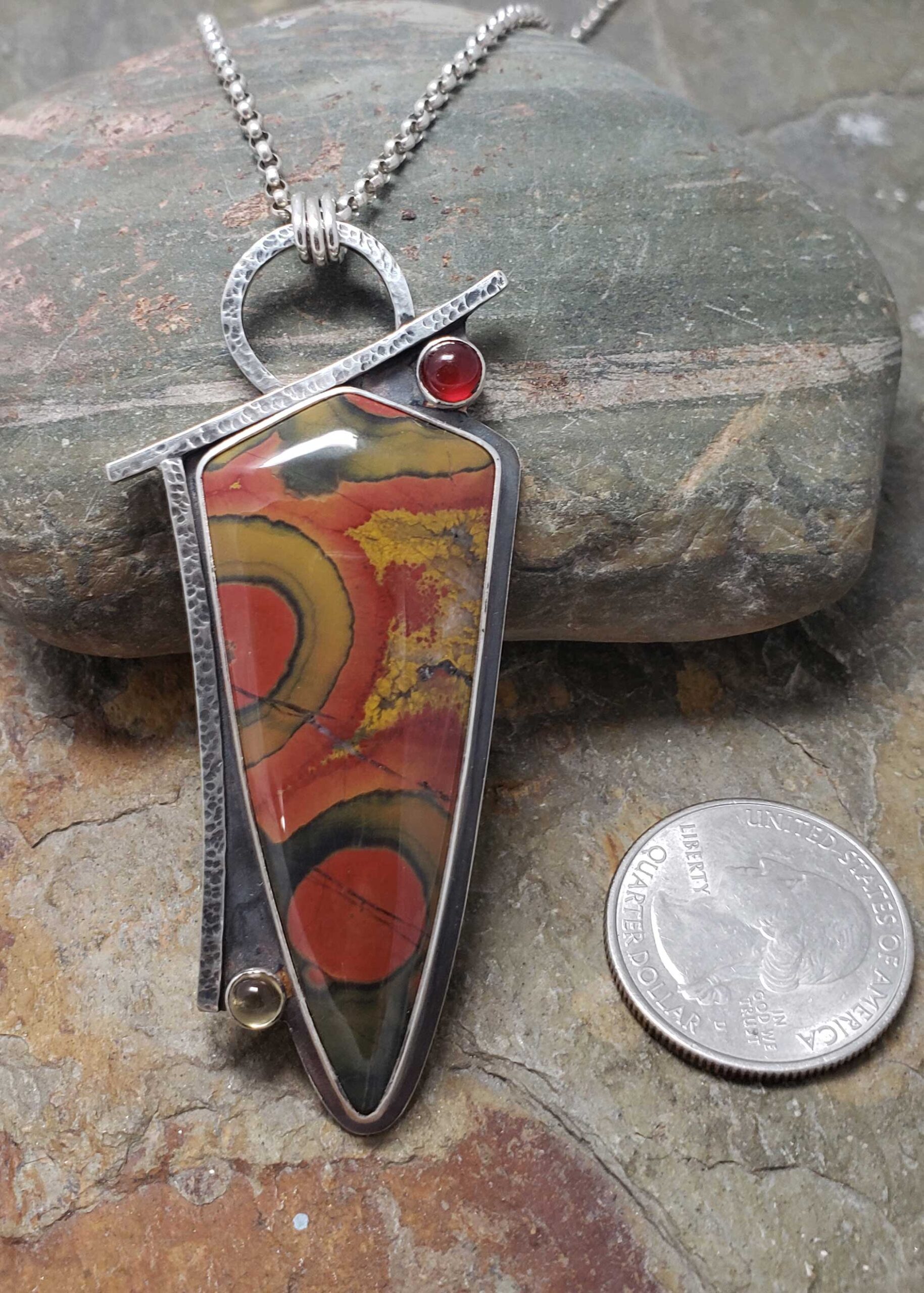 reds, golds and greens make a bold abstract statement in this silver pendant, by Dona Miller