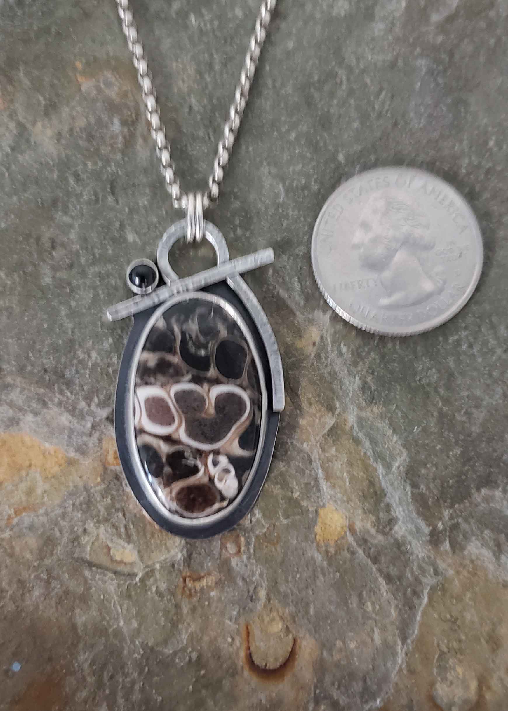 black, white and browns in this fossil stone silver pendant.